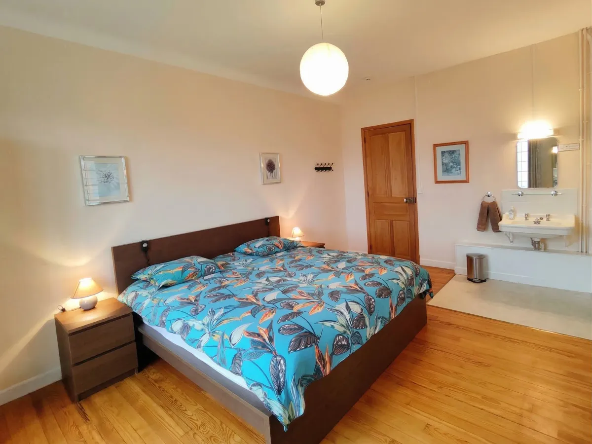 Chambre avec lit double, parquet et lavabo privé