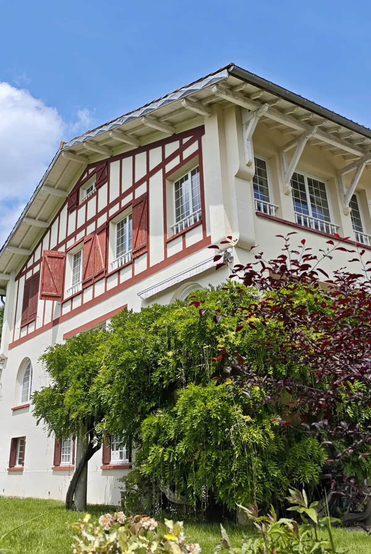 Façade actuelle de HI PYRENEES avec colombages rouges et jardin