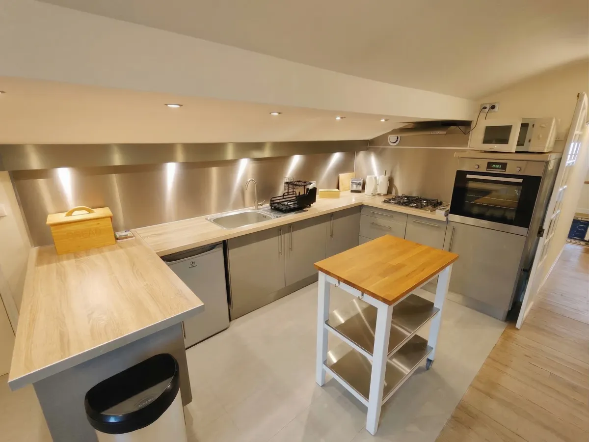 Cuisine moderne en U avec plan de travail et rangements blancs
