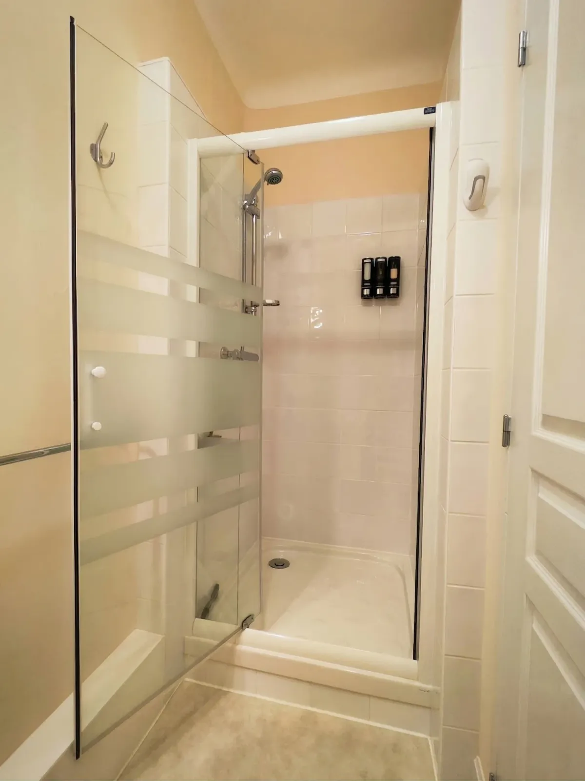 Cabine de douche vitrée avec carrelage blanc